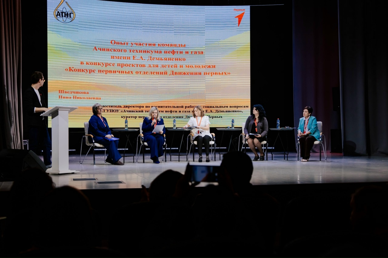 На третьей фотографии видно шесть женщин, сидящих на сцене, и одного мужчину, стоящего возле микрофона. На заднем плане находится экран с текстом, который обозначает название семинара. Женщины одеты в деловые костюмы различных цветов. Атмосфера выглядит формальной и сосредоточенной, с зрителями, сидящими внизу и наблюдающими за обсуждением.