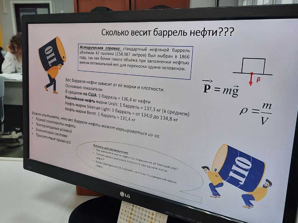 На экране компьютера представлена информация о весе барреля нефти. Текст написан на русском языке с использованием графиков и формул. Изображение веселого персонажа в виде бочки нефти с руками и ногами привлекает внимание. Обсуждаются величины плотности и веса нефти. Ночной фон помещения делает экран более ярким, а сзади видны другие студенты, работающие за столами.