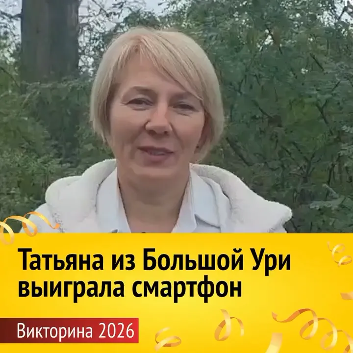 Женщина со светлыми волосами в белой куртке стоит на фоне зеленых деревьев. Внизу желтая плашка с текстом: «Татьяна из Большой Ури выиграла смартфон. Викторина 2026».