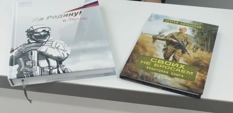 представлены два книги, лежащие на столе. Левая книга называется "За Родину!" и оформлена в патриотическом стиле с изображением солдата в военной форме. Правая книга — "Своих не бросаем" авторства Евгения Киневского, на обложке изображён солдат, идущий по военному пейзажу. Оба произведения имеют серьёзную тематику, вероятно, касающуюся военной службы и патриотизма.