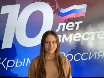 студент на фоне банера с текстом  "1- лет вместе Крым - Россия"
