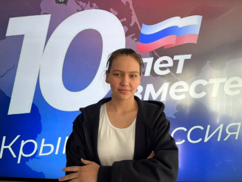 студент на фоне банера с текстом  "1- лет вместе Крым - Россия"