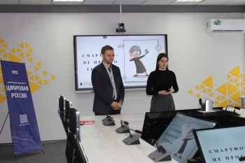 Павел Сергеевич и Дарья Алексеевна, стоят в конференц зале. На фоне интерактивной доски с презентацией