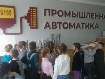 Дети расматривают макет в лаборатории промышелнной автоматики